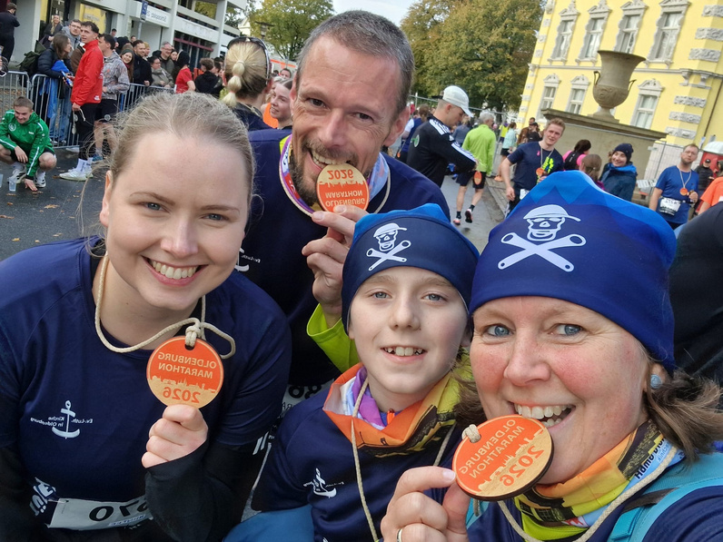 Foto von einer Familie mit zwei Kindern, alle halten stolz ihre Finisher-Medaillen in die Kamera