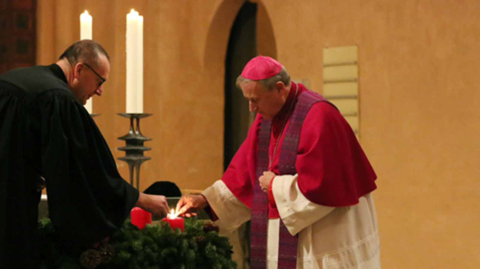 Bischof Thomas Adomeit (links) und Weihbischof Wilfried Theising entzünden gemeinsam den Adventskranz in der evangelischen Alexanderkirche in Wildeshausen. Foto: ELKiO/D.-M. Grötzsch