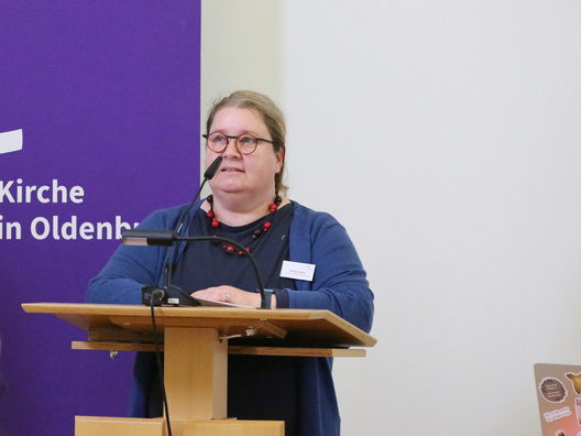 Das Bild zeigt die stellvertretende Ausschussvorsitzende Ulrike Cepin bei der Einbringung des Berichtes aus dem Ausschuss für theologische und liturgische Fragen, Schöpfungsverantwortung, Mission und Ökumene am Rednerpult stehend.