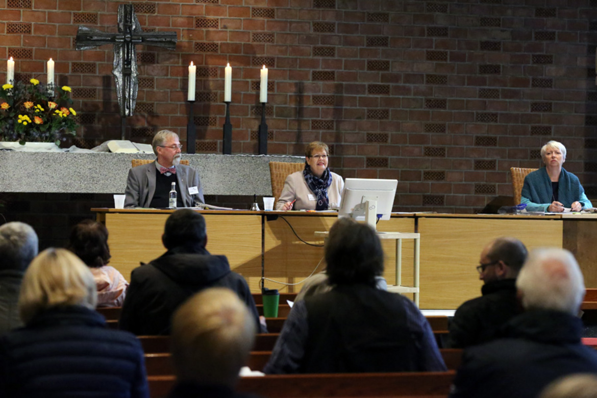 Das Synodenpräsidium vor dem Altar in der St. Johannes Kirche: Synodenvizepräsident Pfarrer Kai Wessels, Synodenpräsidentin Sabine Blütchen und Synodenvizepräsidentin Birgit Osterloh (v.l.n.r.)