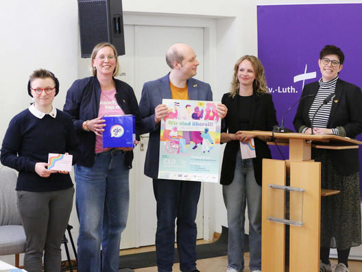 Auf diesem Foto ist zu sehen wie vertretend für queere Menschen in der oldenburgischen Kirche Pfarrerin Jennifer Battram-Arenhövel (sie/ihr), Tom Heymann (er/ihm), Kim König (sie/ihr), Sören Koselitz (er/ihm) und Pfarrerin Nele Schomakers (sie/ihr) Forderungen an die Synode, die auf der Veranstaltungen "Queer gesprochen" gesammelt worden waren, übergeben wurden.
