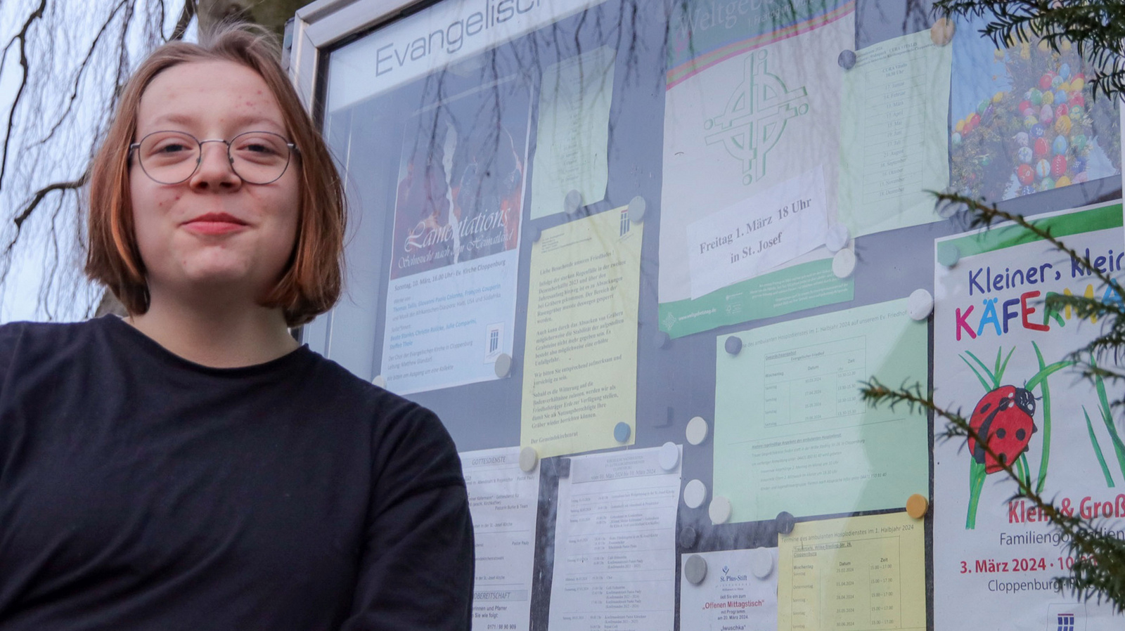 Julia_Berse Julia Berse steht vor dem Schaukasten der Kirchengemeinde Cloppenburg.