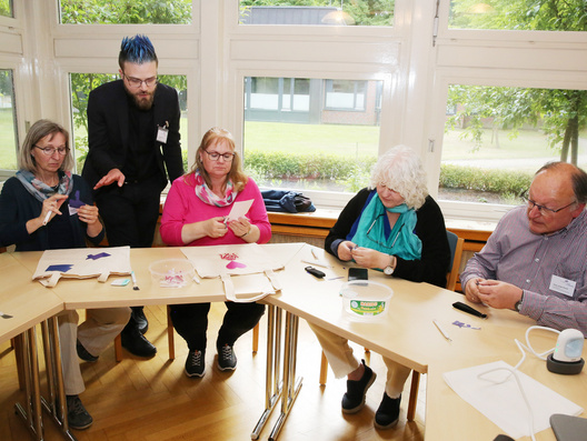 Das Bild zeigt den Workshop „Meine Haltung hat ein Design“ mit Pfarrer Christoph Martsch-Grunau, der Taschen und Schlüsselanhänger  gestaltete.