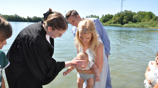 Ein Kind wird von Pfarrerin Katharina Ruhwedel beim Bensheim Tauffest 2022 im Badesee getauft.