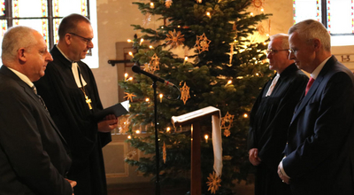 Bischof Thomas Adomeit (2.v.links) und Aufsichtsratsmitglied Ralf Kurzweg (links) bei der Entpflichtung von Pfarrer Thomas Feld und Uwe K. Kollmann.