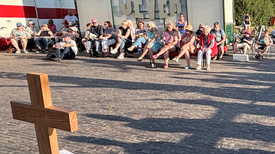 Viele sitzende und singende Menschen bei der "Kirche am Deich" in Dangast.