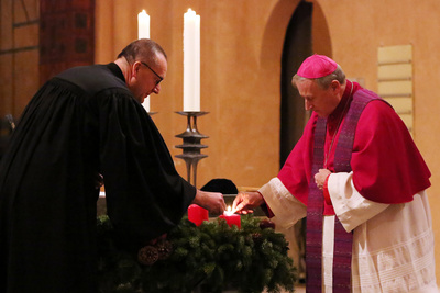 Bischof Thomas Adomeit (links) und Weihbischof Wilfried Theising entzünden gemeinsam den Adventskranz in der evangelischen Alexanderkirche in Wildeshausen. 