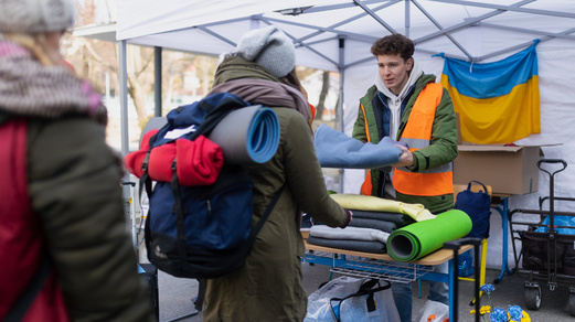 Symbolbild: Flucht, Vertreibung, Asyl Freiwillige verteilen Decken und andere Spenden an Flüchtlinge.