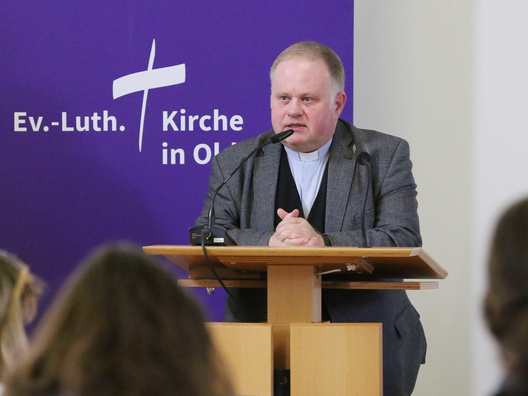Pfarrer Dr. Oliver Dürr steht am Rednerpult.