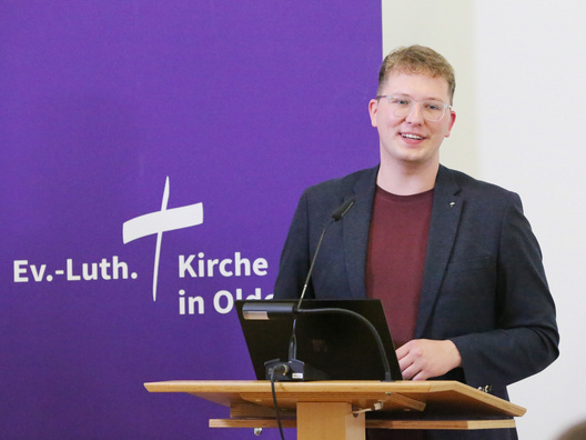 Der Synodenpräsident Chris Schellstede steht bei der Eröffnung der 1. Tagung der 50. Synode am Rednerpult und begrüßt alle Anwesenden.