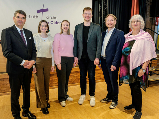 Sechs Personen stehen und schauen in die Kamera.