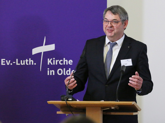 Oberkirchenrat Lars Dede steht am Rednerpult.