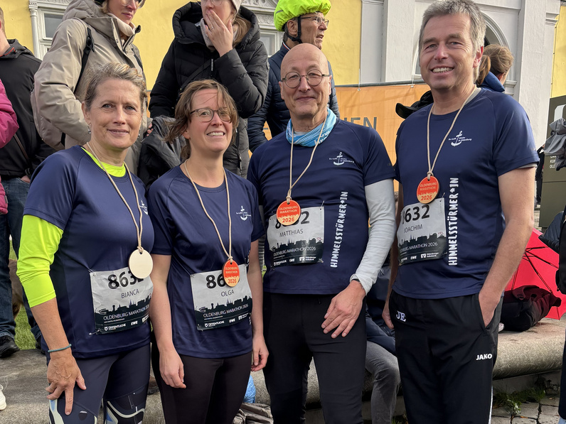 Gruppenfoto, alle vier Personen in blauen "Himmelstürmer"-Shirts und mit Finisher-Medaillen um den Hals