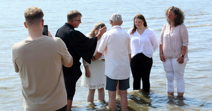 Pastor Dietmar Reumann-Claßen tauft eine Konfirmandin.