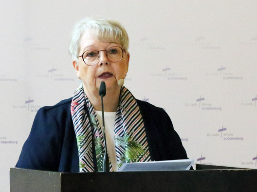 Synodenpräsidentin Sabine Blütchen steht am Rednerpult und spricht.