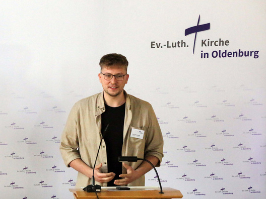 Am Rednerpult steht der Synodale Chris Schellstede.