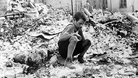 Zu Beginn des Zweiten Weltkriegs sitzt ein polnischer Junge trauernd in den Ruinen einer Straße in Warschau, Polen, September 1939.