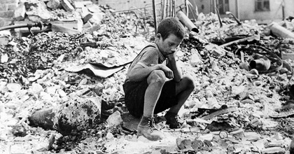 Zu Beginn des Zweiten Weltkriegs sitzt ein polnischer Junge trauernd in den Ruinen einer Straße in Warschau, Polen, September 1939.