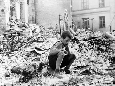 Zu Beginn des Zweiten Weltkriegs sitzt ein polnischer Junge trauernd in den Ruinen einer Straße in Warschau, Polen, September 1939.