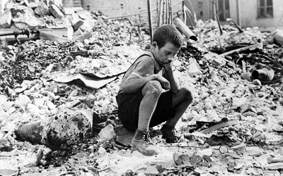 Zu Beginn des Zweiten Weltkriegs sitzt ein polnischer Junge trauernd in den Ruinen einer Straße in Warschau, Polen, September 1939.