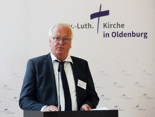 Oberkirchenrat Udo Heinen steht am Rednerpult und spricht.