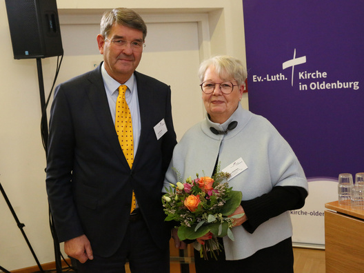 Zwei Personen blicken in die Kamera.