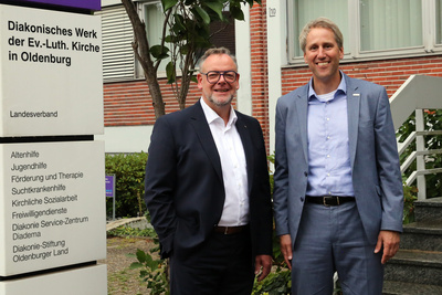 Zu sehen ist Pfarrer Christian Scheuer (links), der ab Januar 2027 gemeinsam mit dem Kaufmännischen Vorstand Mario Behrends (rechts im Bild) die Doppelspitze des Diakonischen Werks bilden wird.