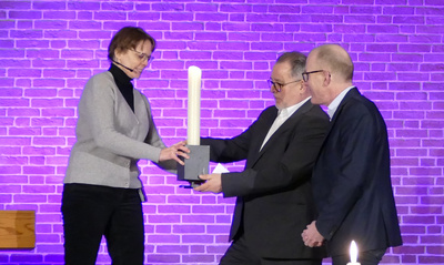 Die Altarkerze übergab Pastorin Ines Heinke an Gerhard Wessels und Wolfgang Hündling von den „Gemeinnützigen Werkstätten Oldenburg“.