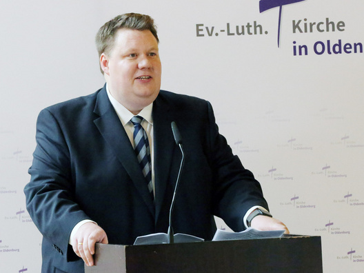 Oberkirchenrat Hauke Smoor steht am Rednerpult und stellt sich vor.