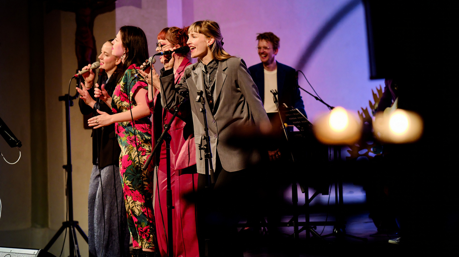 Fünf Personen stehen auf der Bühne, vier Frauen singen im Vordergrund.