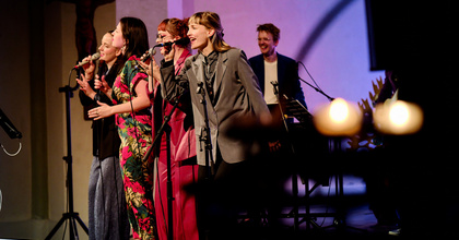Fünf Personen stehen auf der Bühne, vier Frauen singen im Vordergrund.