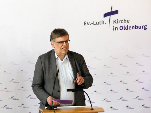 Synodaler Dr. Tim Unger steht am Rednerpult.