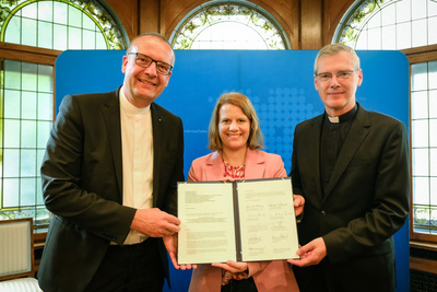 Bischof Thomas Adomeit (links), Kultusministerin Julia Willie Hamburg und Bischof Dr. Heiner Wilmer mit der Vereinbarung zwischen dem Land Niedersachsen und den Kirchen zum neuen Unterrichtsfach Christliche Religion.