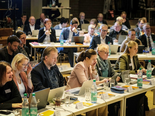 Viele Menschen hören dem Vortragenden zu.