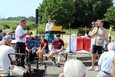 Pfadfinder*innen aus Friedrich-August-Hütte schöpfen mit Eimern und langen Leinen am Union-Pier Taufwasser aus der Weser.