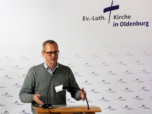 Auf diesem Bild ist der Synodale Tobias Frick am Rednerpult zu sehen.