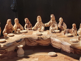 Detailreicher Holzschnitz von Jesus und seinen 12 Aposteln an der Tafel beim Letzten Abendmahl.