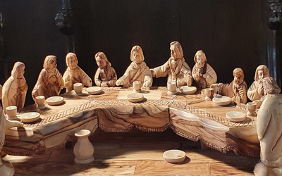 Detailreicher Holzschnitz von Jesus und seinen 12 Aposteln an der Tafel beim Letzten Abendmahl.