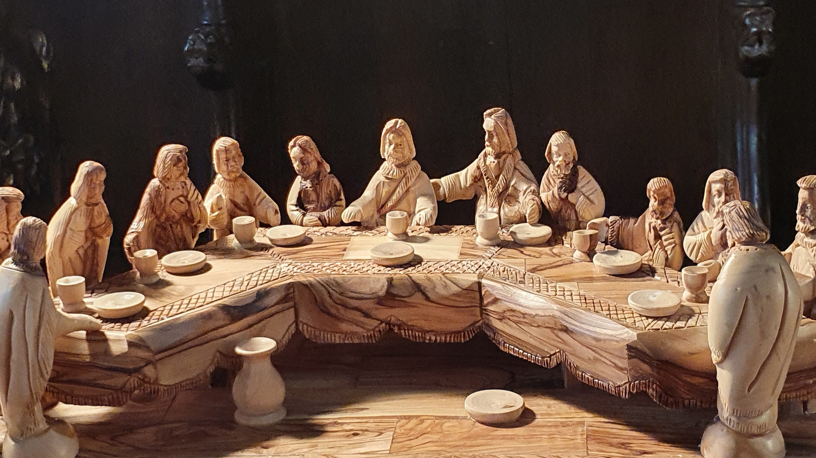 Detailreicher Holzschnitz von Jesus und seinen 12 Aposteln an der Tafel beim Letzten Abendmahl.