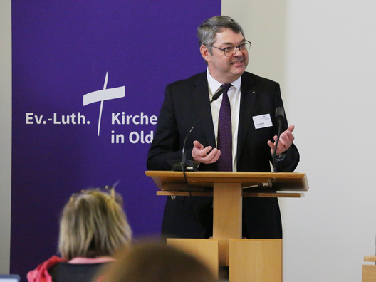 Oberkirchenrat Lars Dede steht am Rednerpult.