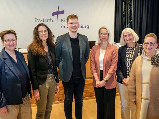 Sechs Menschen stehen vor der Kamera.