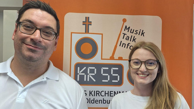 Lucas Söker und Maren Köhne vor einem RollUp vom Kirchenradio Oldenburg