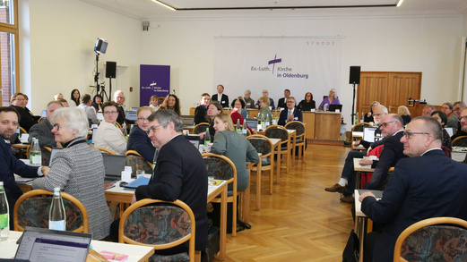 Viele Menschen, die Synode, sitzen in einem großen Raum.