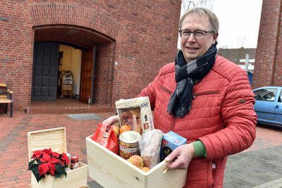 Voslapps Pfarrer Peter Sicking mit der gerade aufgefüllten Voslapper Lebensmittelkiste. Foto: ELKiO/Tobias Frick