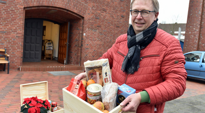 Voslapps Pfarrer Peter Sicking mit der gerade aufgefüllten Voslapper Lebensmittelkiste. Foto: ELKiO/Tobias Frick