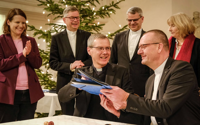 Vertragsunterzeichnung Bischof Dr. Heiner Wilmer, Bistum Hildesheim (links), und Bischof Thomas Adomeit, Ratsvorsitzender der Konföderation evangelischer Kirchen in Niedersachsen (rechts), tauschen die unterschriebene Vereinbarung zum neuen Unterrichtsfach Christliche Religion aus. Links daneben steht die niedersächsische Kultusministerin Julia Willie Hamburg.