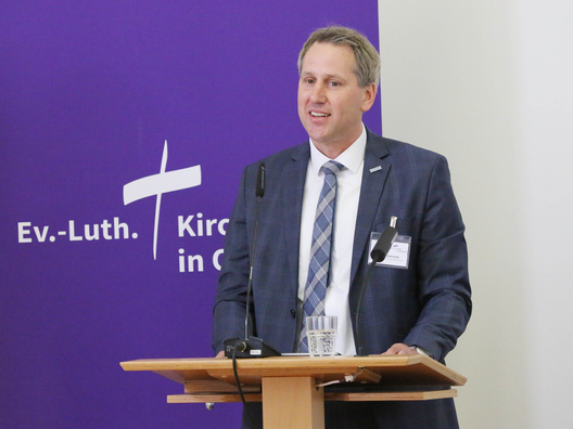 Auf diesem Foto ist Mario Behrends, Kaufmännischer Vorstand der Diakonie im Oldenburger Land zu sehen, wie er den Bericht zur Konsolidierung des Diakonischen Werks der Ev.-Luth. Kirche in Oldenburg e. V. vorstellte.