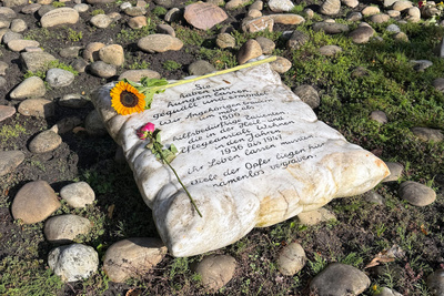 Zu sehen ist ein Gedenkstein auf dem Friedhof der Kirchengemeinde Ofen.
