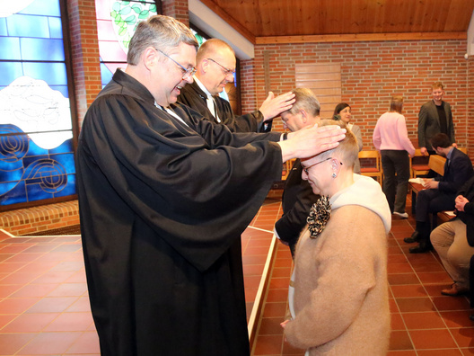 Oberkirchenrat Lars Dede (links) und Bischof Thomas Adomeit (2. von links) segnen Synodale für ihren Dienst in der oldenburgischen Kirche.