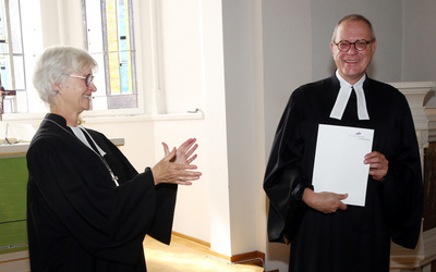 Zu sehen ist Pfarrer Torsten Nowak (rechts), der von Oberkirchenrätin Gudrun Nowak (links) in den Ruhestand verabschiedet worden ist.